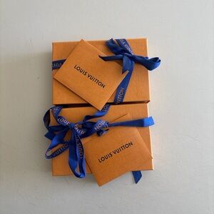Louis Vuitton Orange Boxes with Cream Pouches and Blue Tabs.